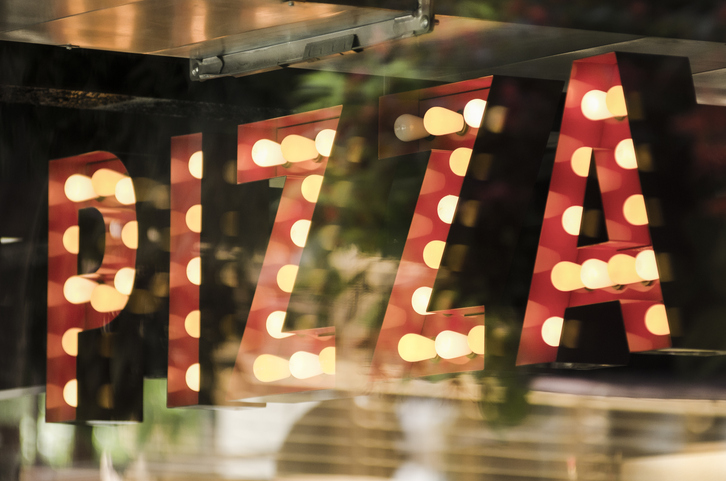 Traditional bulb pizza sign in a bar window