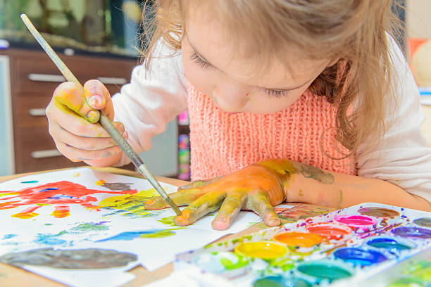 girl drawing paints on paper and hands