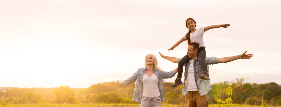 Young happy family in a field.