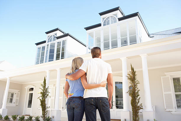 Young Couple Standing Outside Dream Home