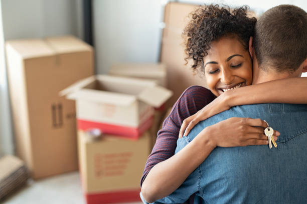 Young african woman holding home keys while hugging