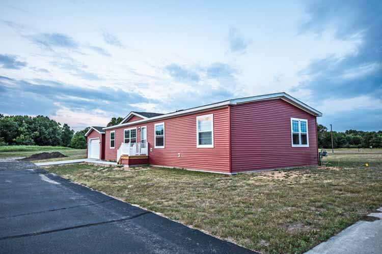 New manufactured home in a new community. The window on the far right on the front shows a reflection of the sunset at the top.