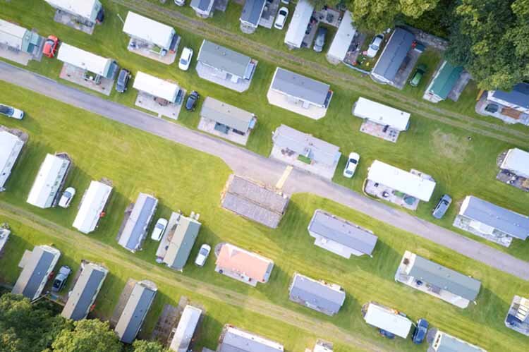 Caravan site park aerial view illuminated by summer sun homes for sale