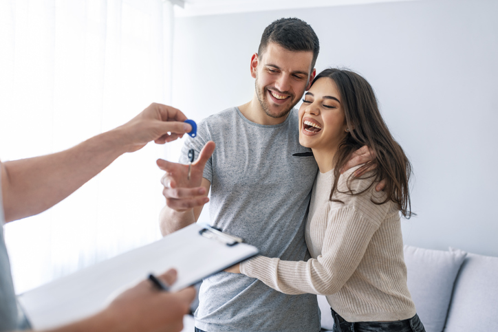 Happy couple is taking keys from their new house