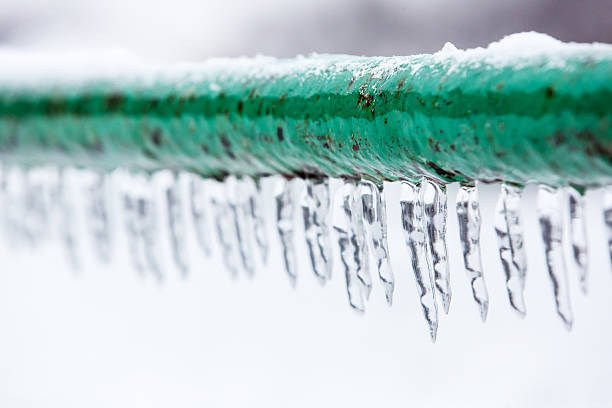 Frozen icy down pipe, icicles all the exposed pipes - plastic or pvc pipes in frozen water heater room