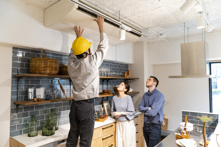 A repairman wearing a yellow helmet 